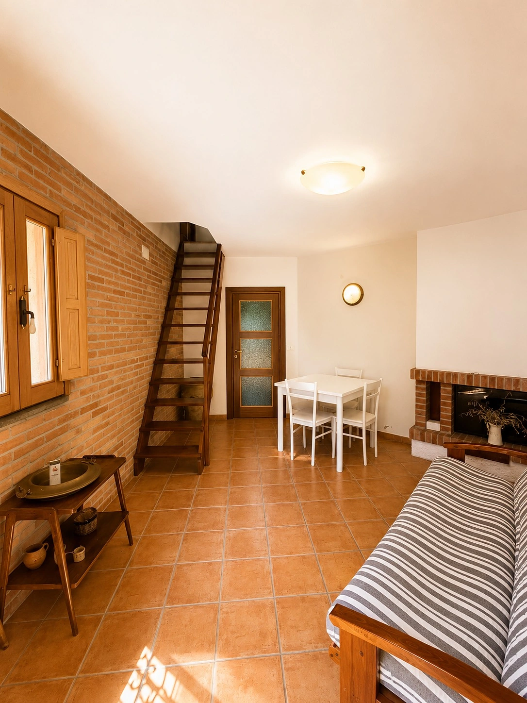 Soggiorno con camino e scala di Casa Milite Ignoto